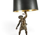 a bronze statue of a boy holding a lamp with a black shade