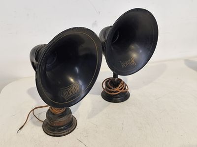 une paire de lampes noires posées sur une table blanche, avec un fond blanc