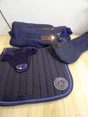 two saddle pads and a saddle bag on a table