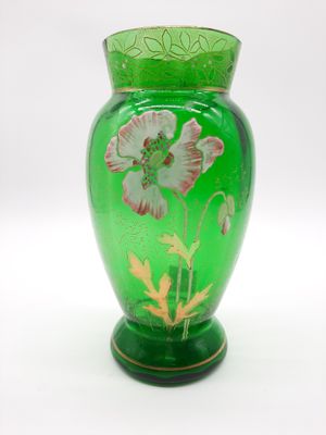 un vase vert orné d'un motif floral