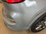 the rear end of a silver car with a red tail light