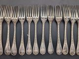 six forks are lined up in a row on a table