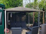 a gazebo with chairs and a table in the middle of the yard