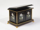 une petite boîte noire décorée de fleurs peintes