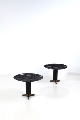 trois tables en marbre noir reposent sur une surface blanche