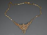 un collier en or avec des perles sur une chaîne