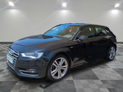 a black audi is parked on a checkered floor in a garage