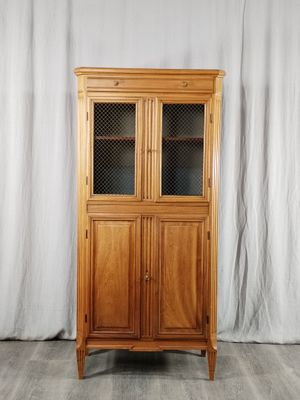 une photo d'une armoire en bois surmontée de portes vitrées