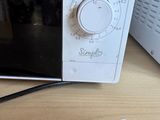 a microwave that is sitting on a table with a remote control