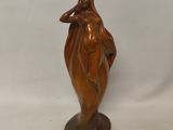 statue en bronze représentant une femme tenant une fleur, posée sur un socle