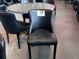 des tables et des chaises dans un restaurant, avec une enseigne accrochée au mur