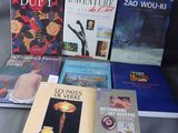 Plusieurs livres sont posés sur une table recouverte d'une nappe grise.