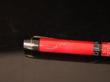 a red pen sitting on top of a black table
