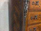 a wooden chest of drawers with a marble top