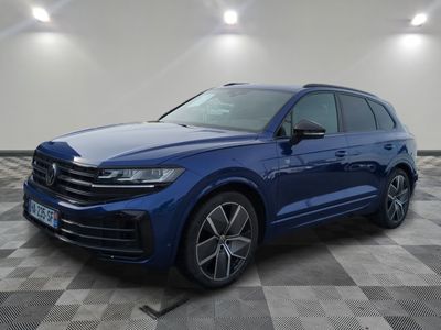 a blue volkswagen suv parked in a room with a checkered floor