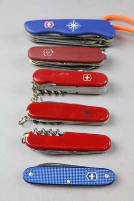 several swiss army knives are lined up on a table