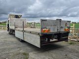 un camion garé sur un parking sous un ciel nuageux