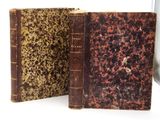 deux vieux livres posés l'un à côté de l'autre sur une surface blanche
