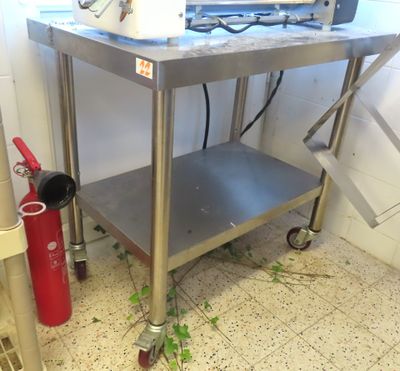 a metal table with a red fire extinguisher next to it