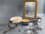 une table sur laquelle se trouvent un miroir, un bol, un bougeoir et d'autres objets