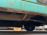 a cat that is sitting under a truck on the street