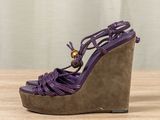a close up of a purple wedged sandal on a wooden table