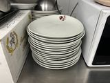 a stack of plates and a microwave in a kitchen