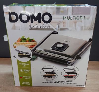 La boîte d'un multi-grill est ouverte sur la table.