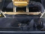 a glass display case with a watch inside of it
