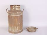 an old milk can and a small bowl on the table