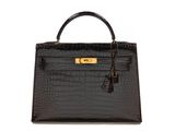 a black crocodile skin handbag with gold hardware on the handle