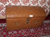 a brown trunk sitting on a red carpet
