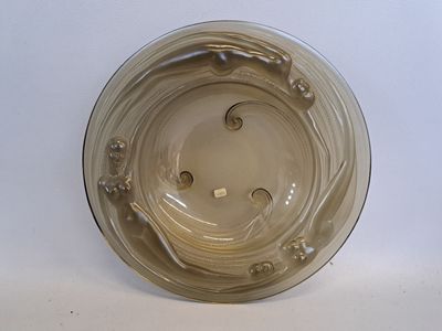 VERLYS Coupe en verre brun à décor de naïades. (Egrenure)