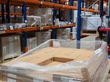 Les cartons sont empilés sur des palettes dans un grand entrepôt rempli de palettes