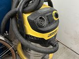 a yellow and black vacuum sitting next to a blue door