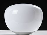 a white vase sitting on a table with a black background