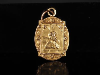 gros plan d'un pendentif en or sur une surface noire