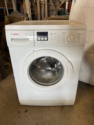 une machine à laver posée sur le sol
