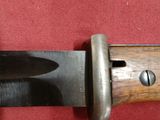 a close up of a knife on a red cloth