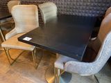 a black table with four chairs and a black table top