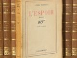 un livre posé sur une étagère, devant une pile de livres