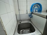 a sink in the corner of a kitchen with a hose in it