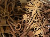 pile of old rusty keys in a white container on a table