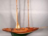 maquette en bois d'un voilier exposée sur un fond blanc