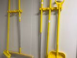 a lot of brooms hanging on the wall in the bathroom