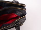 a person holding a black purse with a red lining