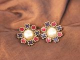 un gros plan sur une paire de boucles d'oreilles posées sur un tissu marron