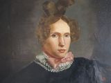 portrait of a woman in a black dress with a pink bow