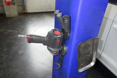 une perceuse fixée à un poteau dans un garage