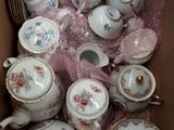 a box full of teapots and saucers in it